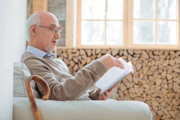 Амбициозный пожилой человек просматривает книгу — стоковое фото