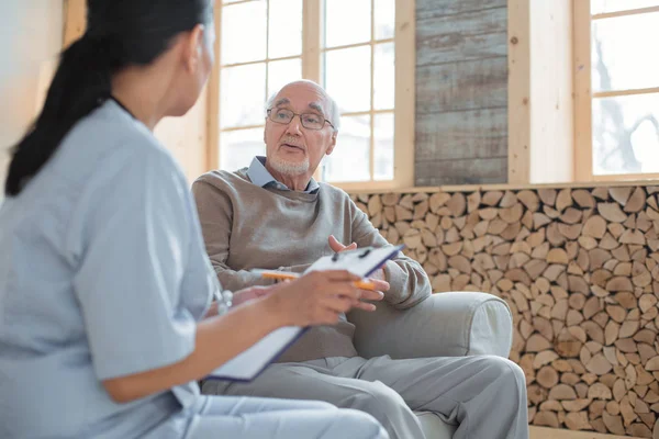 Professionele arts luisteren naar senior mans klacht — Stockfoto