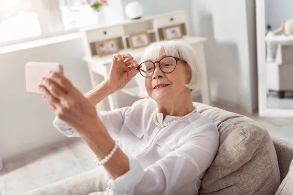 Kellemes idős nő pózol, miközben selfie — Stock Fotó