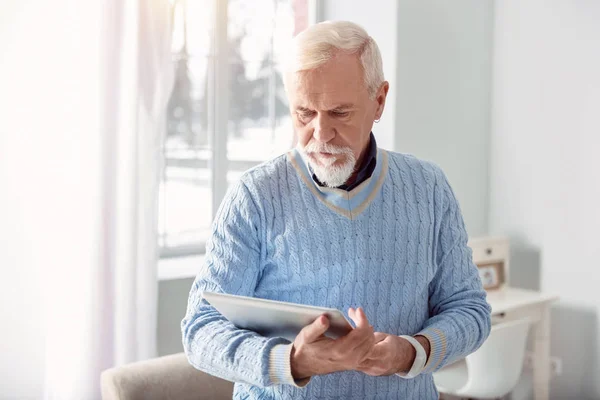 Hombre mayor guapo leyendo desde la tableta — Foto de Stock