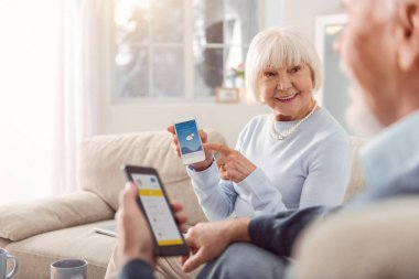 İyimser üst düzey kadın gösteren hava app kocasına