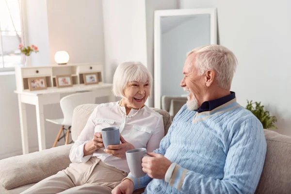 Alegre pareja de ancianos charlando mientras bebe café — Foto de Stock