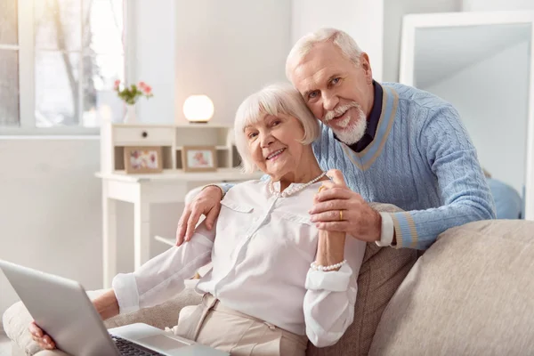 Liefdevolle man knuffelen zijn vrouw terwijl ze werken — Stockfoto