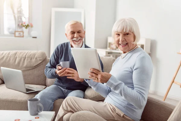 Vidám idősebb pár olvasó póznák szociális média, és nevetve — Stock Fotó
