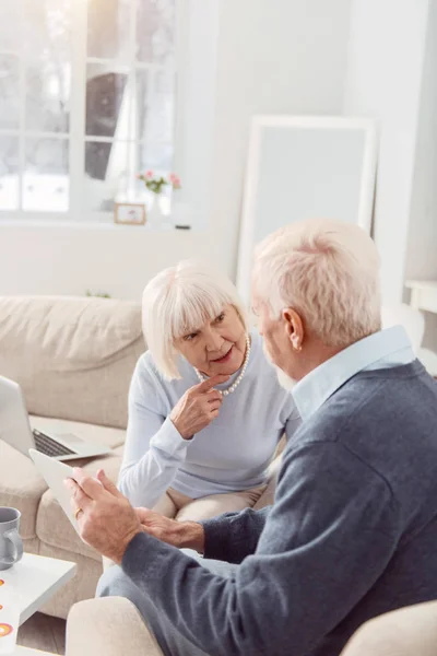 Seniorpaar spricht über Weltgeschehen, während es Nachrichten online liest — Stockfoto