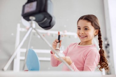 Genç ama deneyimli. Fotoğraf makinesinde bir makyaj eğitimi filme ve yeni bir toz için test çok önceden genç kız