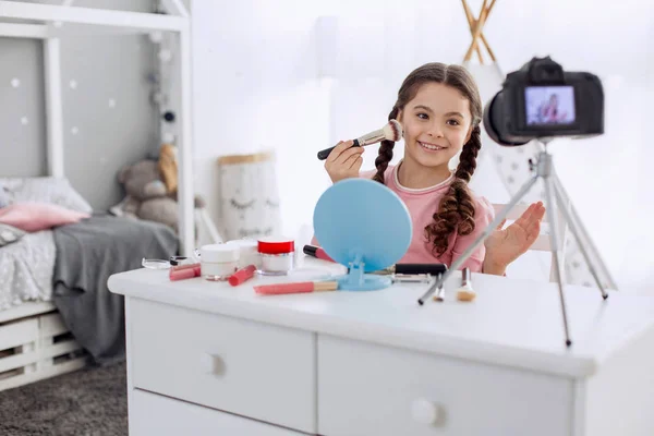 Fröhliches Pre-Teenie-Mädchen spricht vor der Kamera über Make-up-Grundlagen — Stockfoto