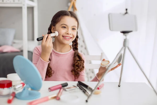 Menina bonito filmar tutorial de maquiagem com seu telefone — Fotografia de Stock