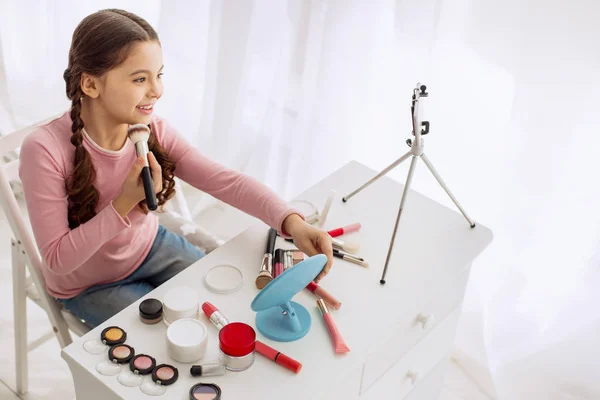 Trevlig pre-tonåring tjej överprövnings makeup produkter lever — Stockfoto