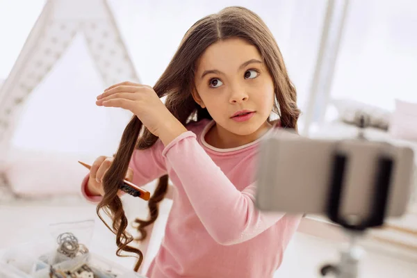 Dulce chica cepillándose el pelo y filmando —  Fotos de Stock