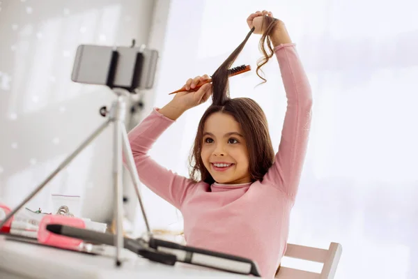 Menina feliz gravando-se enquanto escova o cabelo — Fotografia de Stock