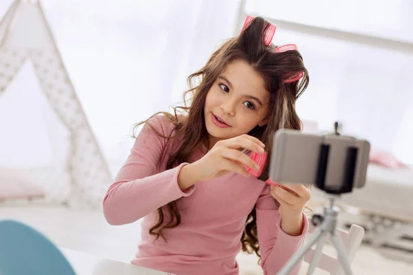 Beautiful pre-teen girl recording hair rollers tutorial — Stock Photo, Image