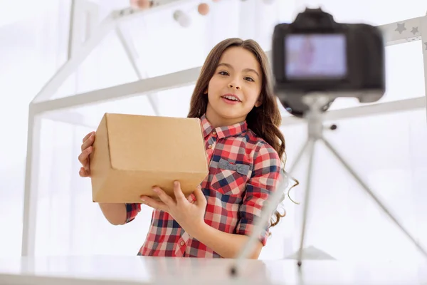 Chica alegre grabación unboxing vídeo en la cámara — Foto de Stock