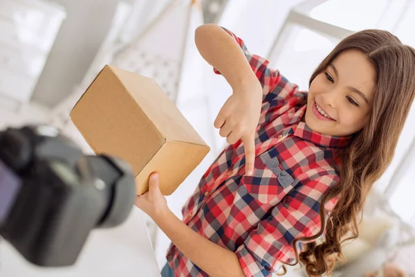 Chica alegre adivinando el contenido de la caja mientras graba vlog — Foto de Stock