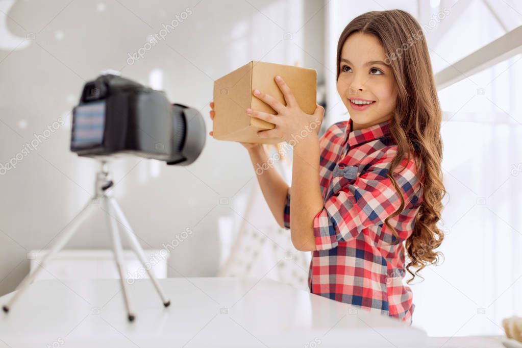 Cute girl guessing box content while recording vlog