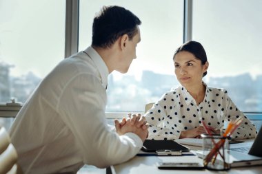 İyimser meslektaşları ortak proje üzerinde çalışırken gülümsüyor alışverişi