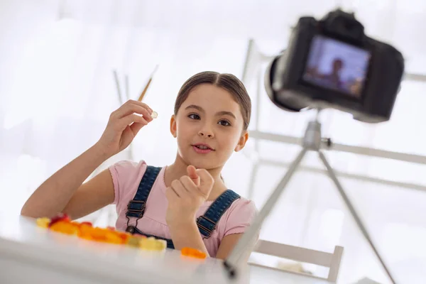 Upbeat pre-teen girl reviewing gummies in her video blog — Stock Photo, Image