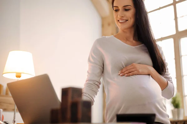Vigorous pregnant woman searching movie — Stock Photo, Image