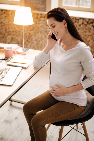 Весела вагітна жінка використовує смартфон — стокове фото