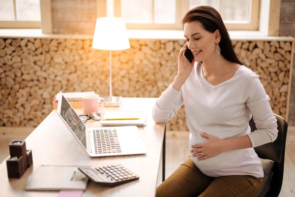 Optimistické těhotná žena pomocí telefonu — Stock fotografie