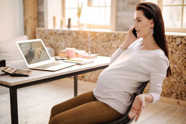 Schöne schwangere Frau tratscht am Telefon — Stockfoto