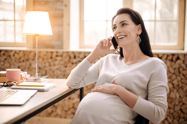 Gioiosa donna incinta che chiede consigli al telefono — Foto Stock