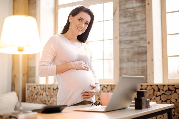 Fröhliche schwangere Frau arbeitet während der Schwangerschaft — Stockfoto