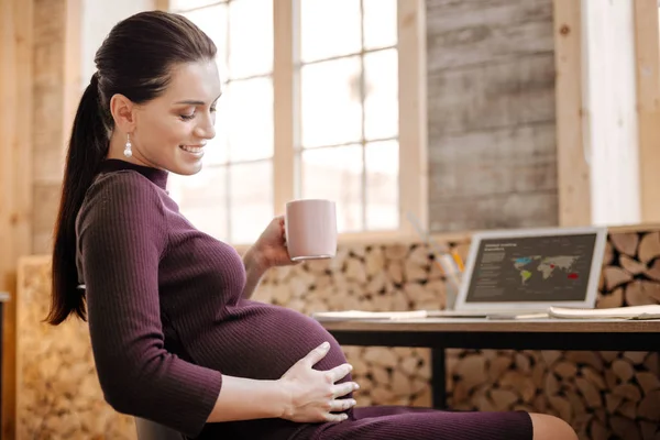 Adorable pregnant businesswoman caressing her tummy — Stock Photo, Image