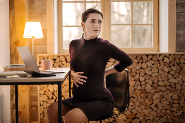 Besorgte verärgerte schwangere Geschäftsfrau spürt Wehen — Stockfoto