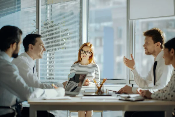 Angenehme junge Kollegen, die während der Besprechung Aufgaben besprechen — Stockfoto