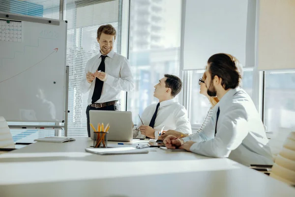 Angenehmer Mann, der seinen Kollegen von der Arbeit berichtet — Stockfoto