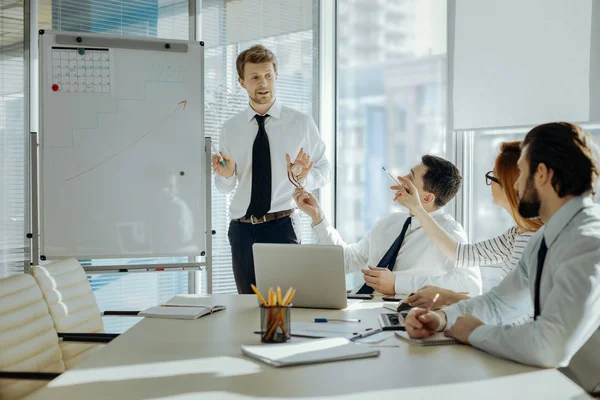 Alegre jefe explicando los objetivos del proyecto a sus empleados —  Fotos de Stock