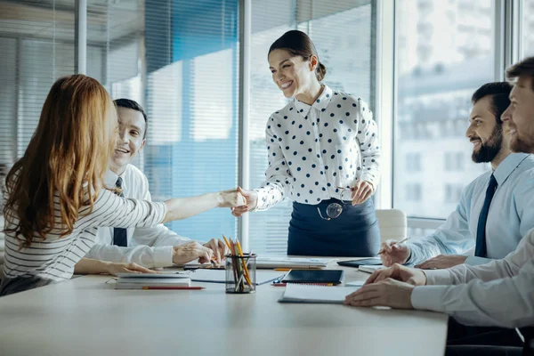 Alegre jefe estrechando la mano con su colega mujer durante la reunión — Foto de Stock