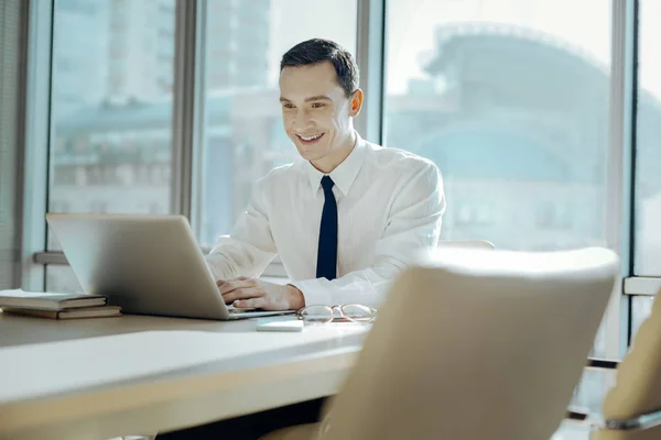 Hombre alegre trabajando en el ordenador portátil con sonrisa en la cara — Foto de Stock