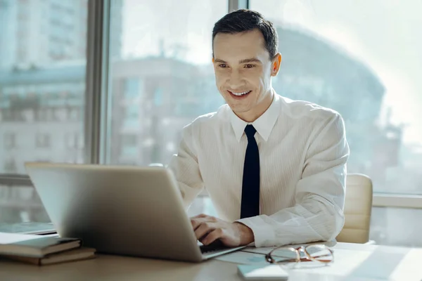 Аптечний чоловік створює презентацію на ноутбуці і посміхається — стокове фото