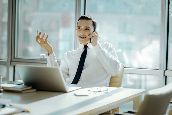 Hombre alegre teniendo una agradable conversación telefónica en la oficina — Foto de Stock