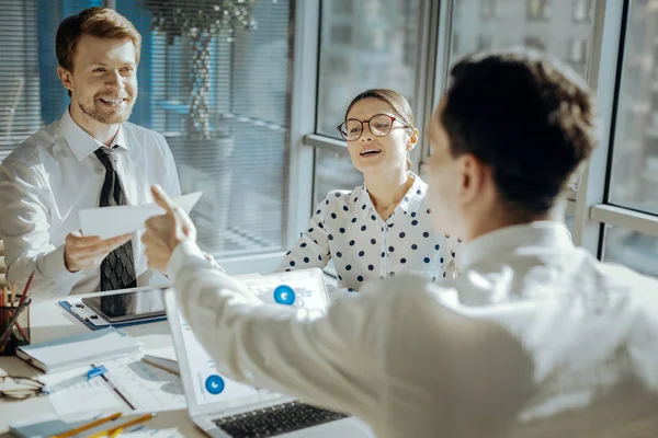 Lächelnder Manager überreicht seinem Kollegen Dokumente — Stockfoto