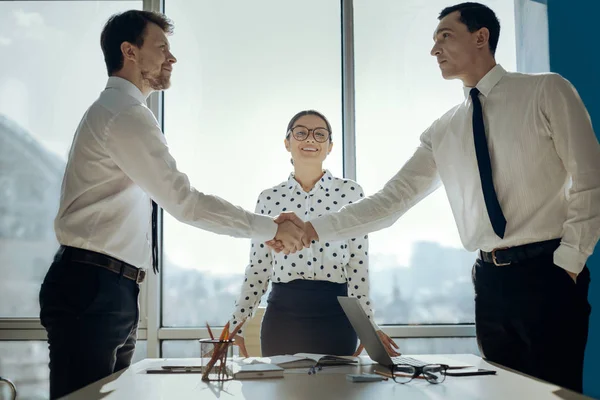 Красиві бізнесмени тремтять руками, домовившись про угоду — стокове фото
