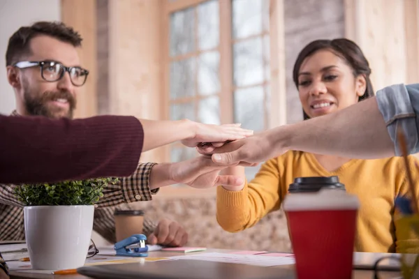 Glada trevliga människor att sätta händerna ihop — Stockfoto