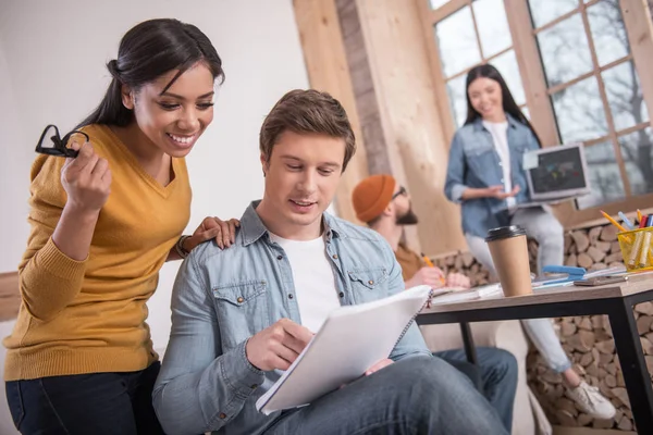 Agradable hombre encantado señalando las notas — Foto de Stock