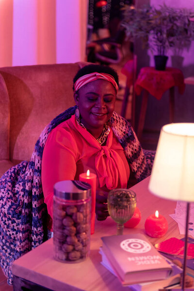 African american plump fortune-teller in ethnic adornments getting ready for work