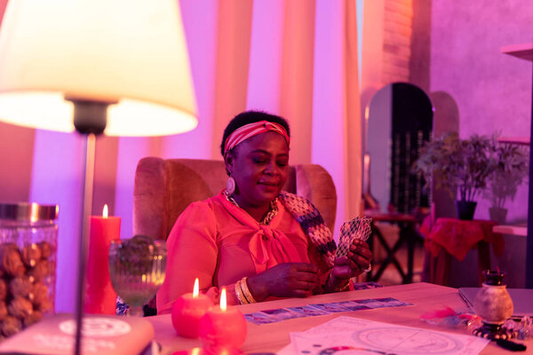 African american plump fortune-teller with huge earrings doing cards reading