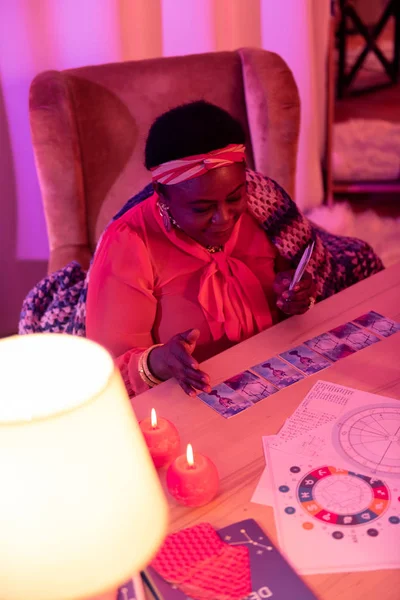 African american plump fortune-teller with huge earrings working with Tarot — Stock Photo, Image