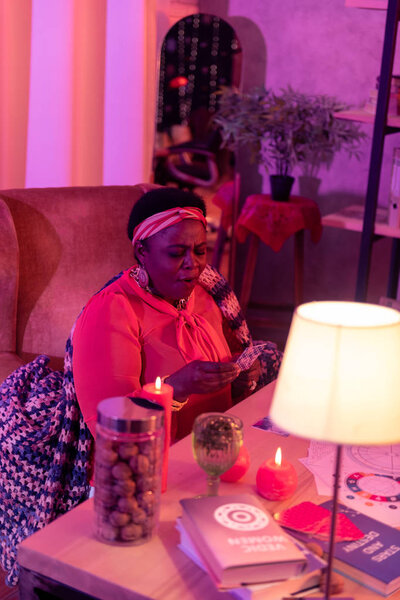 African american plump fortune-teller with huge earrings looking astonished