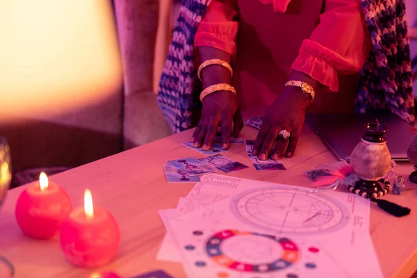 Africká americká baculatá věštkyně s zlaté náramky přesouvání karet — Stock fotografie