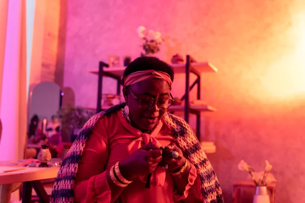 Africká americká baculatá věštkyně s velkými kroužky v salonu věštění — Stock fotografie