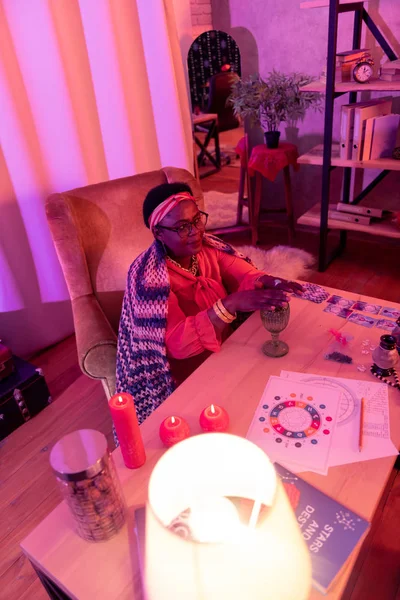 African american plump fortune-teller with a golden watch looking amused — Stock Photo, Image