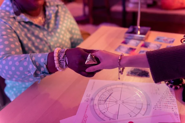 Adivino afroamericano con un enorme anillo estrechando la mano con una mujer — Foto de Stock