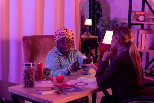 African american plump fortune-teller with a huge ring looking suspicious — Stock Photo, Image