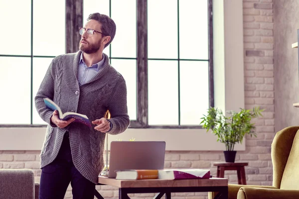 Hombre guapo y guapo sosteniendo un libro sobre astrología — Foto de Stock